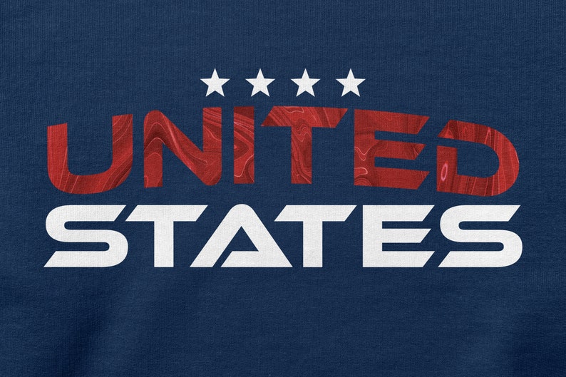 Op de afbeelding: Een marineblauw t-shirt met een rood en wit grafisch ontwerp dat "UNITED STATES" zegt met vijf witte sterren boven het woord "UNITED".