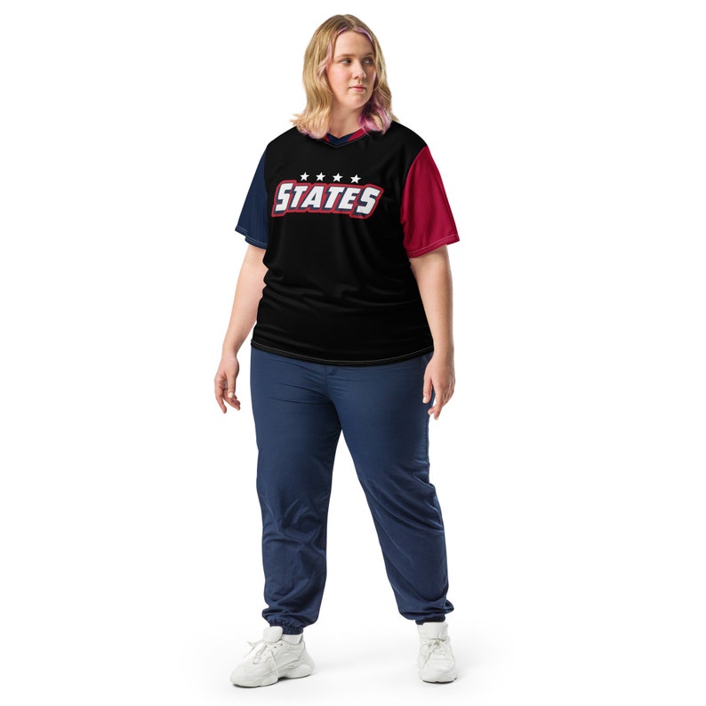 May include: A black and red t-shirt with a white and blue "STATES" graphic. The shirt has a red and blue color block design.