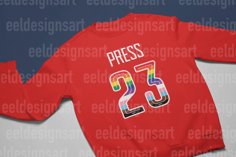 Puede incluir: Sudadera roja con el n&uacute;mero 23 en colores arco&iacute;ris y la palabra "PRESS" encima.