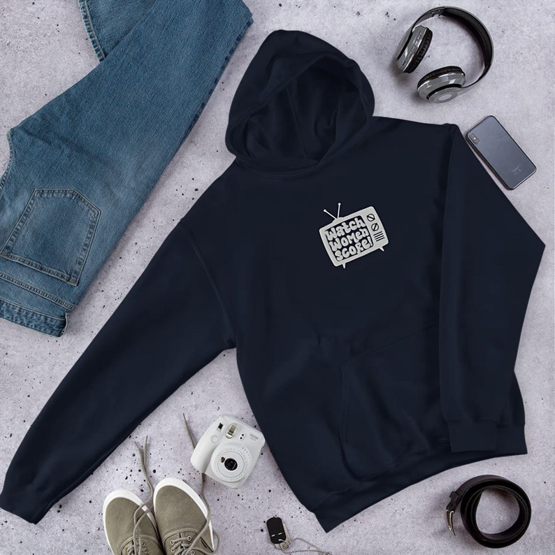 May include: A navy blue hoodie featuring a white graphic of a vintage television screen with the text "Watch Women Score!" printed on it.