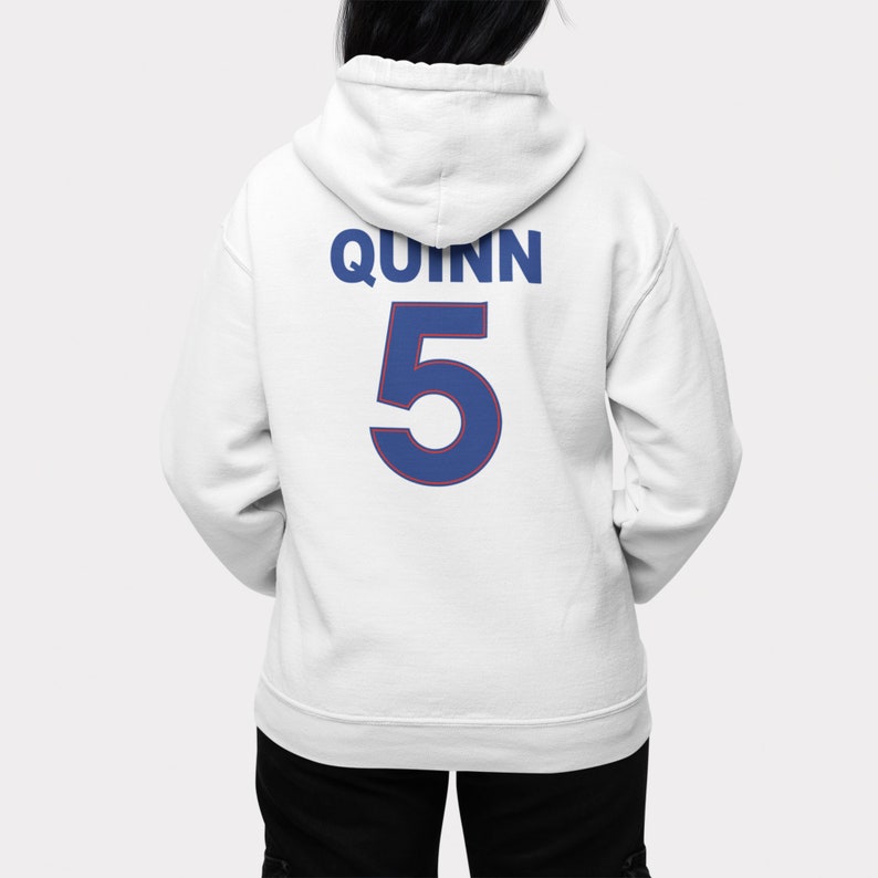 May include: White hoodie with the name "QUINN" and the number "5" printed on the back in blue with a red outline.
