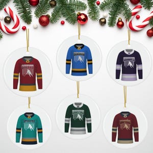 May include: Six round ceramic ornaments featuring hockey jerseys with team names and logos. The jerseys are in the colors of the teams: red, blue, green, maroon, teal, and purple. The ornaments are perfect for hockey fans.
