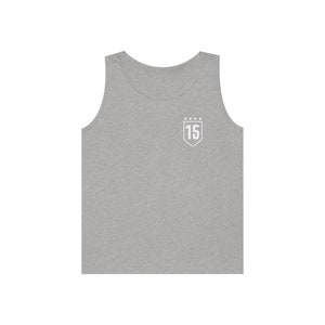 Puede incluir: Camiseta sin mangas gris con un parche blanco en forma de escudo que muestra el n&uacute;mero "15" y cinco estrellas arriba.