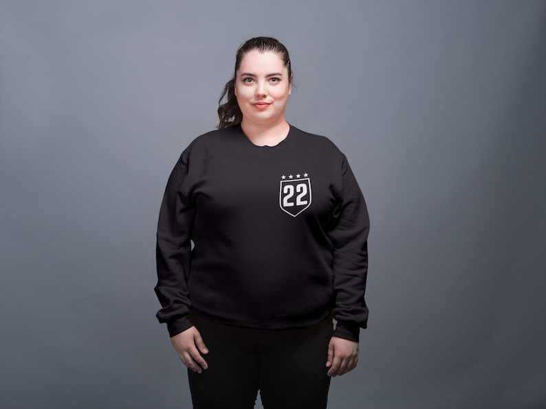 May include: A black sweatshirt with a white shield design featuring the number 22 and five stars.