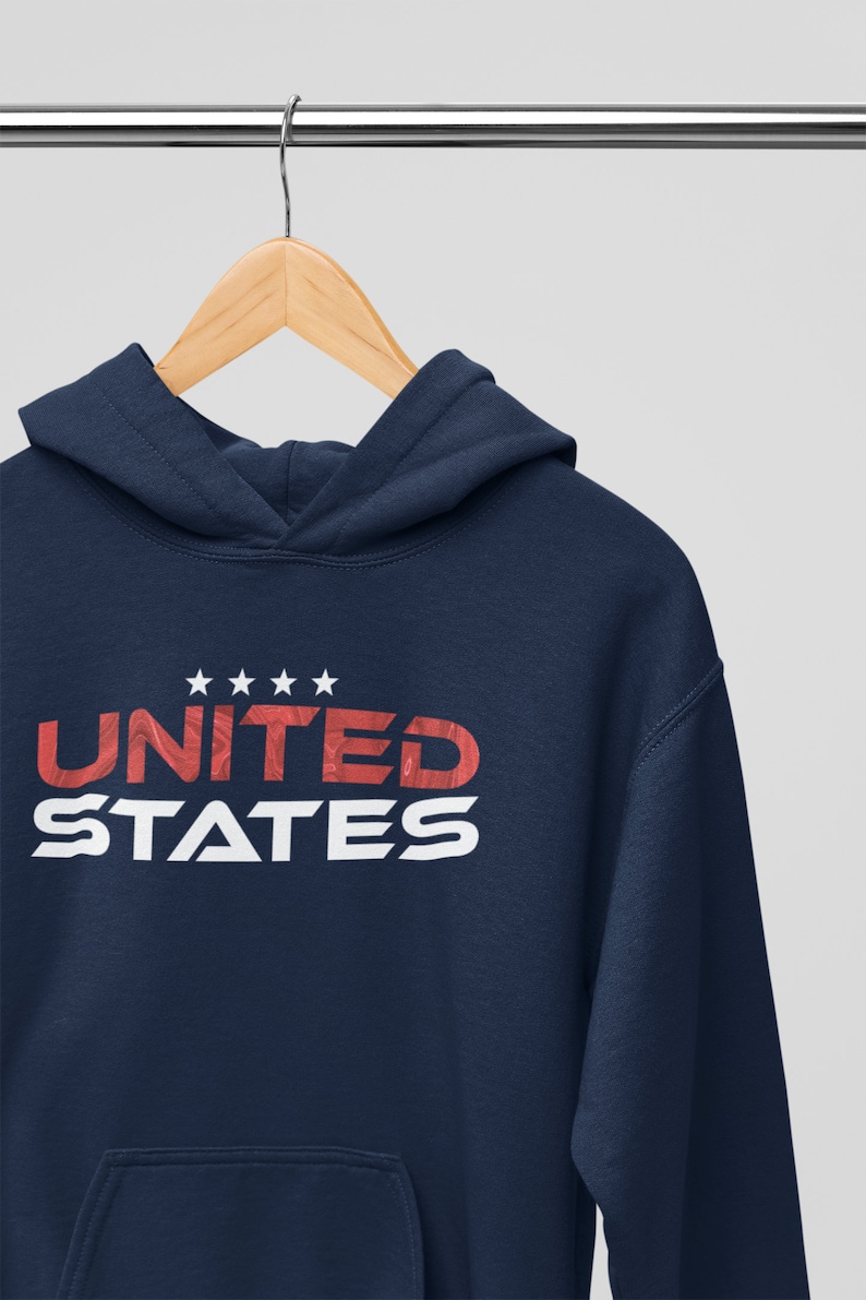 Op de afbeelding: Een marineblauwe hoodie met een witte zak en de tekst "UNITED STATES" in rood-witte letters.