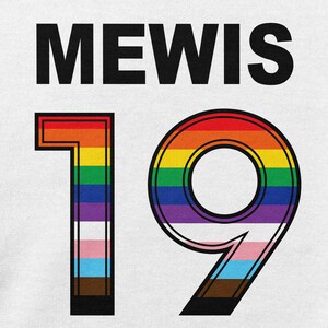 Puede incluir: Una camiseta blanca con el nombre "MEWIS" y el n&uacute;mero "19" en negro con un contorno de colores arco&iacute;ris.