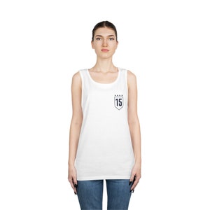 Puede incluir: Camiseta blanca sin mangas con un parche azul marino en forma de escudo con el n&uacute;mero "15" y cinco estrellas arriba.