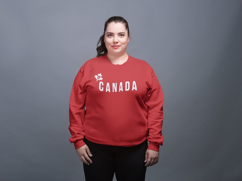 May include: A red sweatshirt with a white maple leaf and the word "CANADA" printed on the front.