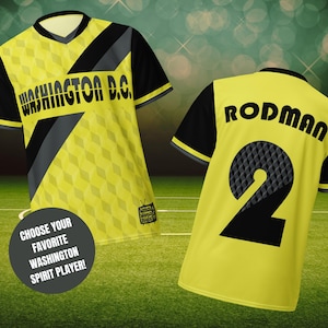 May include: Two yellow and black football shirts with the text "WASHINGTON D.C." on the front of one shirt and "RODMAN 2" on the back of the other shirt.
