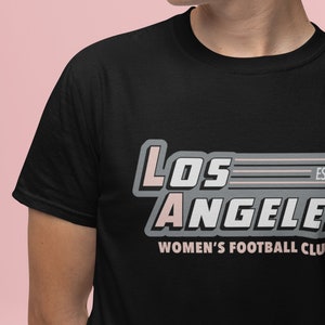 Pu&ograve; includere: T-shirt nero con la scritta "Los Angeles Women's Football Club" in un design retr&ograve;. Il testo &egrave; in bianco, rosa e grigio. La maglietta &egrave; a girocollo.
