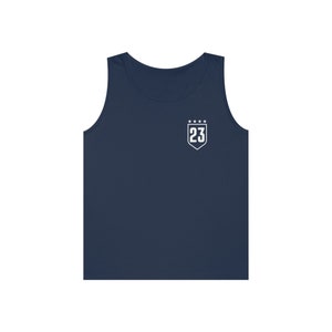 May include: A navy blue sleeveless tank top with a white shield-shaped patch featuring the number 23 and five stars.
