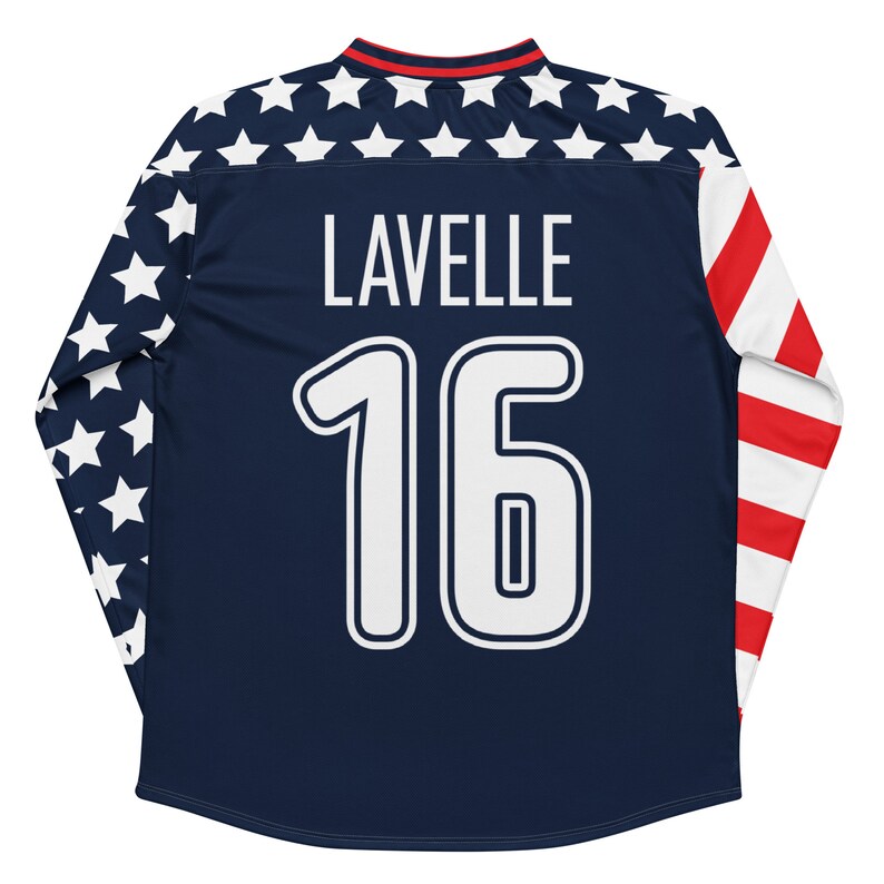May include: A navy blue long-sleeved soccer jersey with white stars on the sleeves and a red, white, and blue stripe on the right sleeve. The jersey has the name "LAVELLE" and the number "16" printed on the back in white.