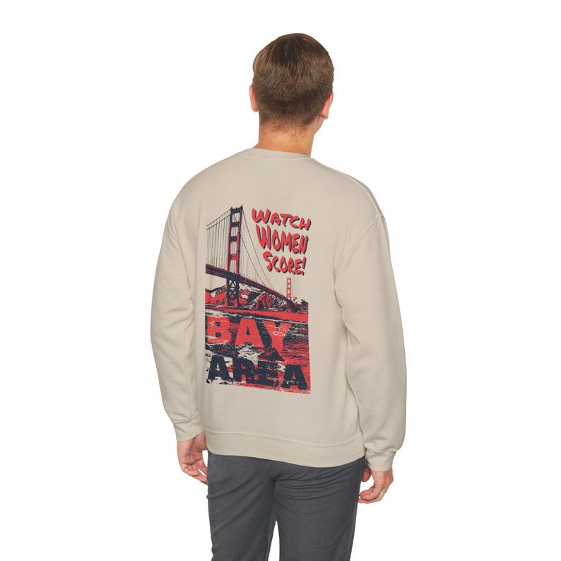 May include: A light gray sweatshirt with a graphic print of the Golden Gate Bridge and the text "Watch Women Score! Bay Area" in red and blue.