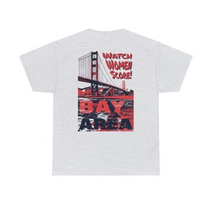 May include: A grey t-shirt with a red and blue graphic of the Golden Gate Bridge and the text "Watch Women Score! Bay Area".