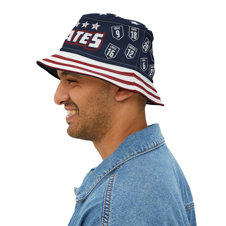May include: A blue and red bucket hat with the word "ATES" and numbers on it. The hat has a white brim and a red, white, and blue striped band.