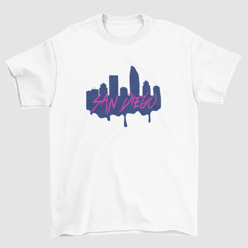 May include: White t-shirt with a navy blue silhouette of the San Diego skyline with the text "SAN DIEGO" in pink dripping paint.
