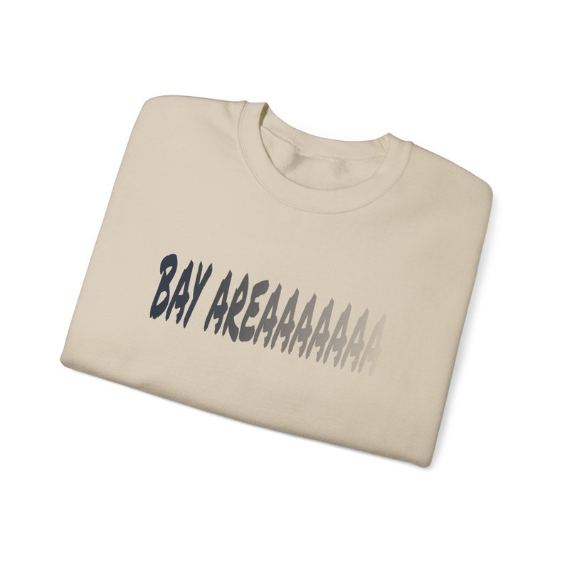 May include: A beige t-shirt with the text "BAY AREAAAAAAA" printed in black on the front.