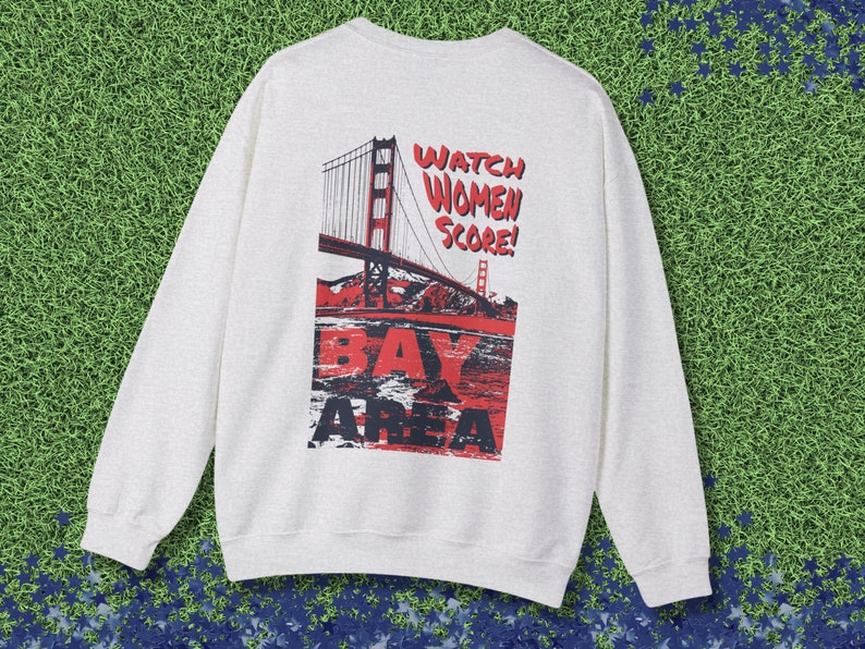 May include: A light gray sweatshirt with a graphic print of the Golden Gate Bridge and the text "Watch Women Score! Bay Area".
