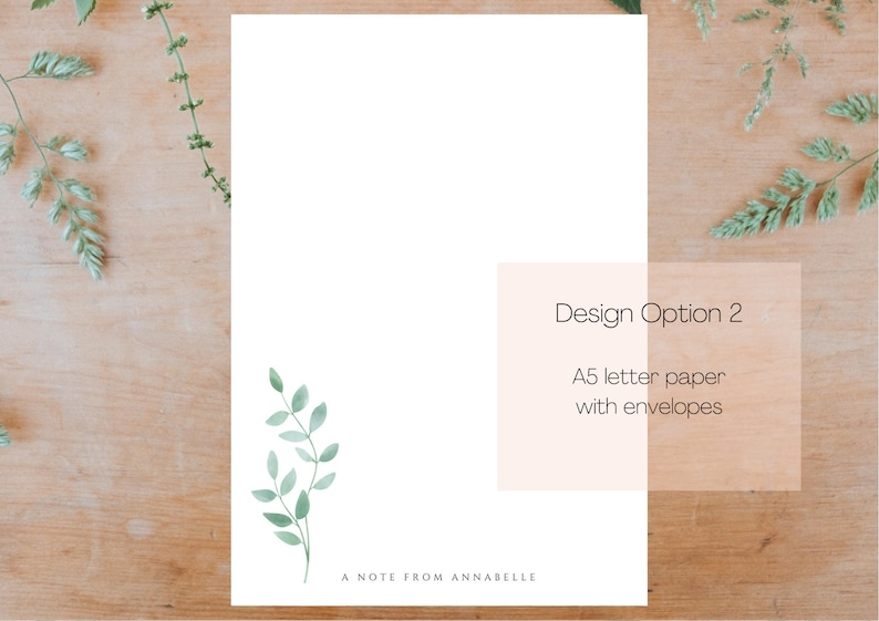 May include: A white card with a green watercolor leaf design. The card has the text "A Note From Annabelle" at the bottom. The card is on a wooden surface with green leaves. The text "Design Option 2" and "A5 letter paper with envelopes" is on a peach background.