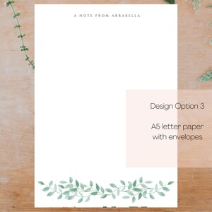 May include: A white notecard with the text "A Note From Arabella" at the top. The notecard has a green leafy border at the bottom. The text "Design Option 3" is in a white box with a peach background. The text below says "A5 letter paper with envelopes".