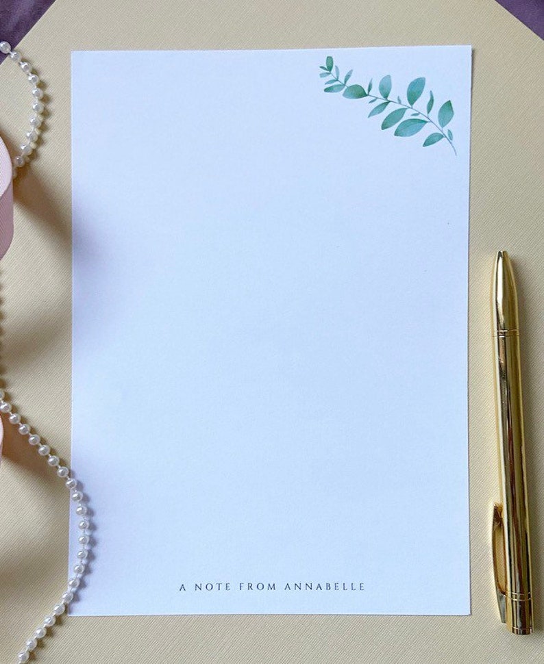 May include: A white stationery sheet with a green leafy branch design in the top right corner. The text "A note from Annabelle" is printed at the bottom of the sheet.
