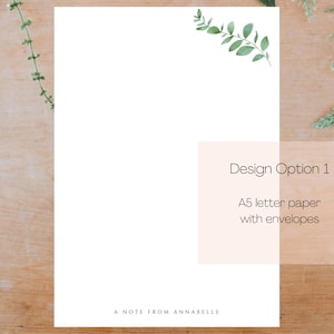 May include: A white card with a green leafy branch design in the top right corner. The card has the text "Design Option 1" and "A5 letter paper with envelopes" in black text. The card also has the text "A Note From Annabelle" at the bottom.