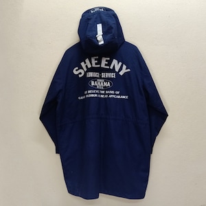 May include: A navy blue long-sleeved jacket with a hood. The jacket has a white logo that says "SHEENY ADVANCE-SERVICE BANANA WELL IT BELIEVE THE BASIS OF GOOD FASHION IS NEAT APPEARANCE".