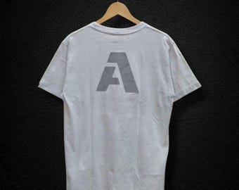 Camiseta vintage con el logotipo de AVIREX A, blanca, para hombre, talla M, estilo urbano, con gráficos, estilo minimalista, estilo militar, estilo retro de los años 90.