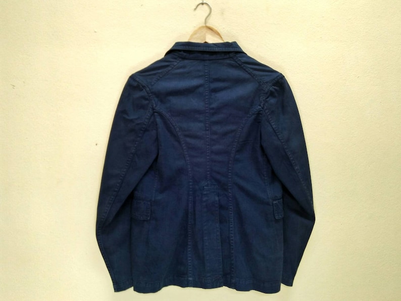 May include: A dark blue blazer with long sleeves and a button closure. The blazer has a classic style and is made of a smooth, textured fabric.