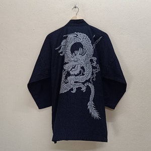 May include: A black kimono with a silver dragon design on the back. The kimono has a traditional Japanese style.