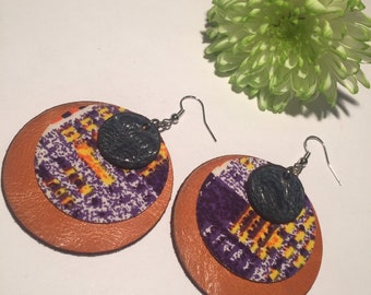 ROUND ORANGE EARRINGS, textured navy blue leather layered above & orange below, vibrant purple fabric creating layers of African charm