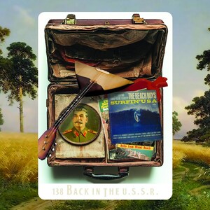 May include: An open brown suitcase filled with items including a balalaika, a portrait, and a record album. The album cover reads "Surfin' USA" by The Beach Boys. The text "138 Back in the U.S.S.R." is at the bottom.