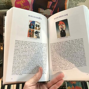 May include: Open book with two pages displayed. One page features a colorful illustration with the text "119 HELLO GOODBYE." The opposite page has an illustration with the text "120 THE INNER LIGHT."