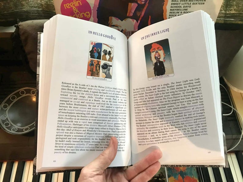 May include: Open book with two pages displayed. One page features a colorful illustration with the text "119 HELLO GOODBYE." The opposite page has an illustration with the text "120 THE INNER LIGHT."