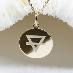 Peut inclure: Collier avec pendentif en or, orné d'un charm circulaire gravé d'un symbole représentant un triangle avec une ligne horizontale le traversant.