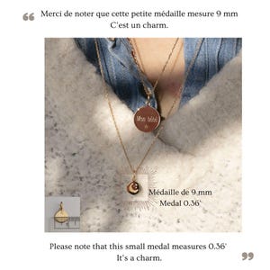 May include: A gold necklace with two charms. The larger charm is a round disc with the inscription "Mon b&eacute;b&eacute;" and a small star. The smaller charm is a round disc with a crescent moon and a star design. The necklace is shown on a person wearing a white sweater and a blue denim shirt. The text "M&eacute;daille de 9 mm Medal 0.36'" is shown below the smaller charm. The text "Please note that this small medal measures 0.36' It's a charm." is shown below the image.