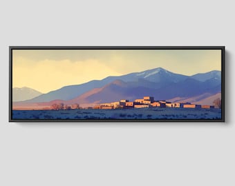 May include: A panoramic framed wall art print depicting a desert landscape with a cluster of adobe-style buildings at the base of layered blue mountains under a soft yellow sky. The artwork is enclosed in a thin black frame with a clean edge.