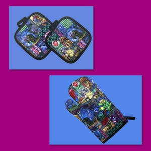 May include: Two square pot holders and an oven mitt with a colorful stained-glass design. The design features images of characters, roses, and geometric shapes in shades of blue, green, red, and yellow. The pot holders have black trim and a black loop.