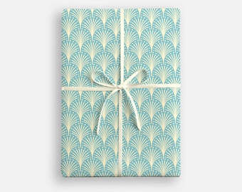 May include: A gift wrapped in blue and cream wrapping paper with a white ribbon. The paper has a repeating pattern of stylized fans.