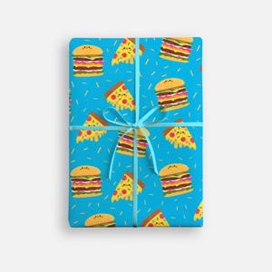 May include: A wrapped gift with a blue background featuring a repeating pattern of cartoon hamburgers and pizza slices. The gift is tied with a light blue ribbon and bow. The wrapping paper has a fun, playful design.
