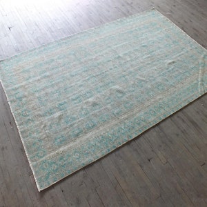 K&ouml;nnte beinhalten: Ein hellblauer und wei&szlig; gemusterter Teppich mit einem dezenten geometrischen Design. Der Teppich ist aus einem weichen, gewebten Material gefertigt und hat einen Used-Look.