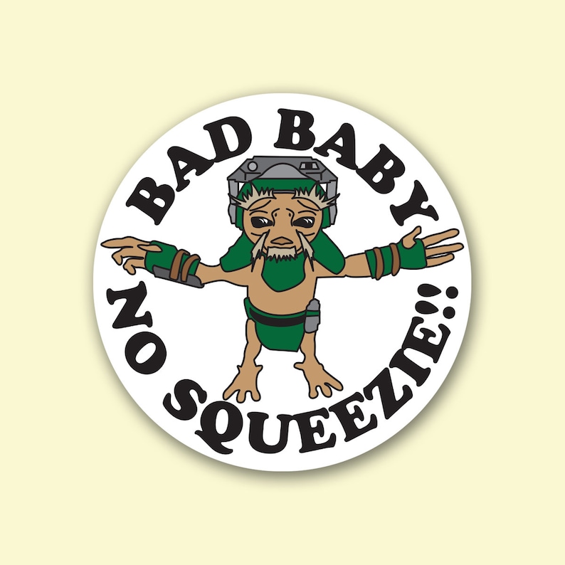 May include: A round sticker featuring a cartoon alien with green and brown skin, wearing a helmet and green armbands. The text "BAD BABY" and "NO SQUEEZIE!!" are printed around the alien in a bold, black font.
