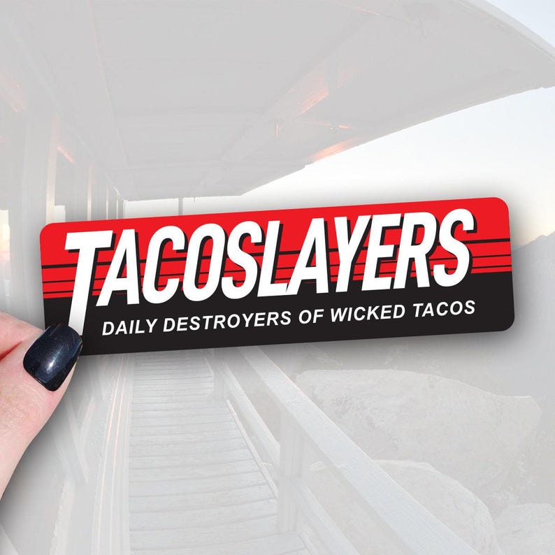 A sticker with the text TACOSLAYERS printed on it, along with the phrase DAILY DESTROYERS OF WICKED TACOS.