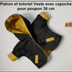 May include: Black and yellow quilted jacket with a hood for a 36 cm doll. The jacket has a zipper closure and two pockets. The jacket is made of a soft, quilted fabric.