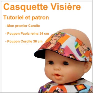 Op de afbeelding: Een pop met een kleurrijk vizier met een zwarte rand. Het vizier heeft een Frida Kahlo-geïnspireerd ontwerp met oranje, rode en witte patronen. De tekst in het Frans luidt: "Casquette Visière, Tutoriel et patron."