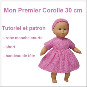 Pode incluir: Uma boneca vestindo um vestido e uma faixa de cabelo rosa, com o texto "Mon Premier Corolle 30 cm" e "Tutoriel et patron". O vestido tem um padrão floral. A boneca tem aproximadamente 30 cm de altura.