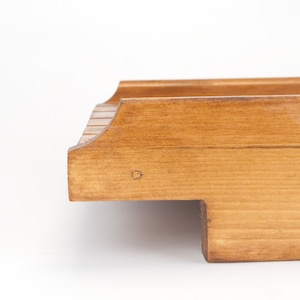 May include: A wooden serving tray with a natural finish. The tray has a rectangular shape with rounded edges and a raised lip.