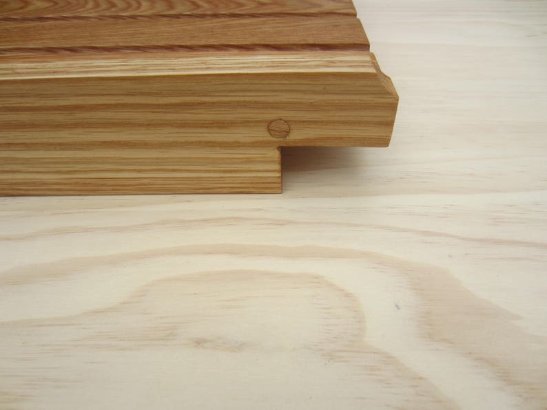 K&ouml;nnte beinhalten: Nahaufnahme eines Schneidebretts aus Holz mit nat&uuml;rlicher Oberfl&auml;che. Das Brett hat eine gerillte Oberfl&auml;che und eine abgerundete Kante.