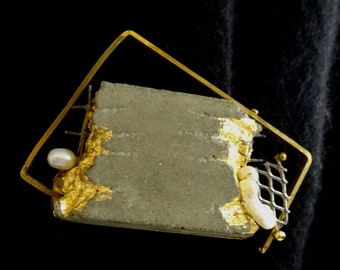 Brooch in concrete and gold, contemporary jewel "Precious remains... in the frame...".