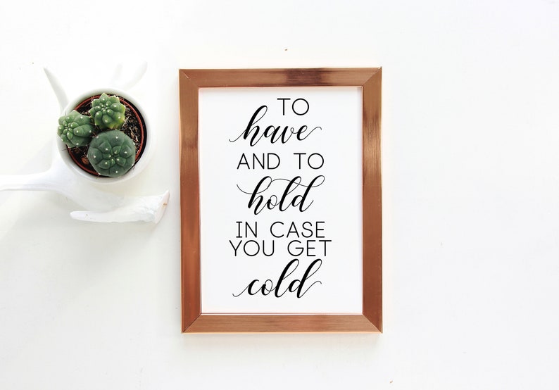 May include: A framed print with a copper colored frame and a white background. The print features black calligraphy text that reads "To have and to hold in case you get cold."